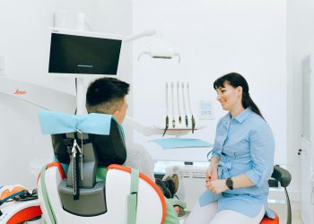 Dentist interacting with patient in a bright, modern dental clinic.