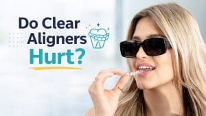 women with black glasses holding clear aligners